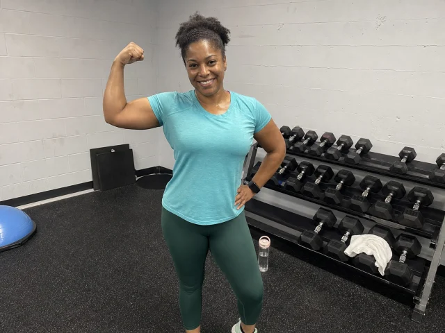 Woman casually showing her arm strength after a gym workout